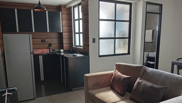 A modern kitchen with a built-in oven, a sink, and a window.