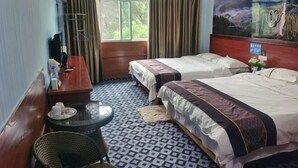 A hotel room with two beds, a small table, a chair, a window with curtains, and a painting on the wall. - Congjian Huadu Hotel (Congjiang)
