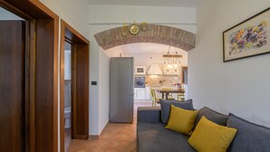 Ein gemütliches Wohnzimmer mit grauem Sofa, gelben Kissen und einem Kamin aus Ziegelsteinen.