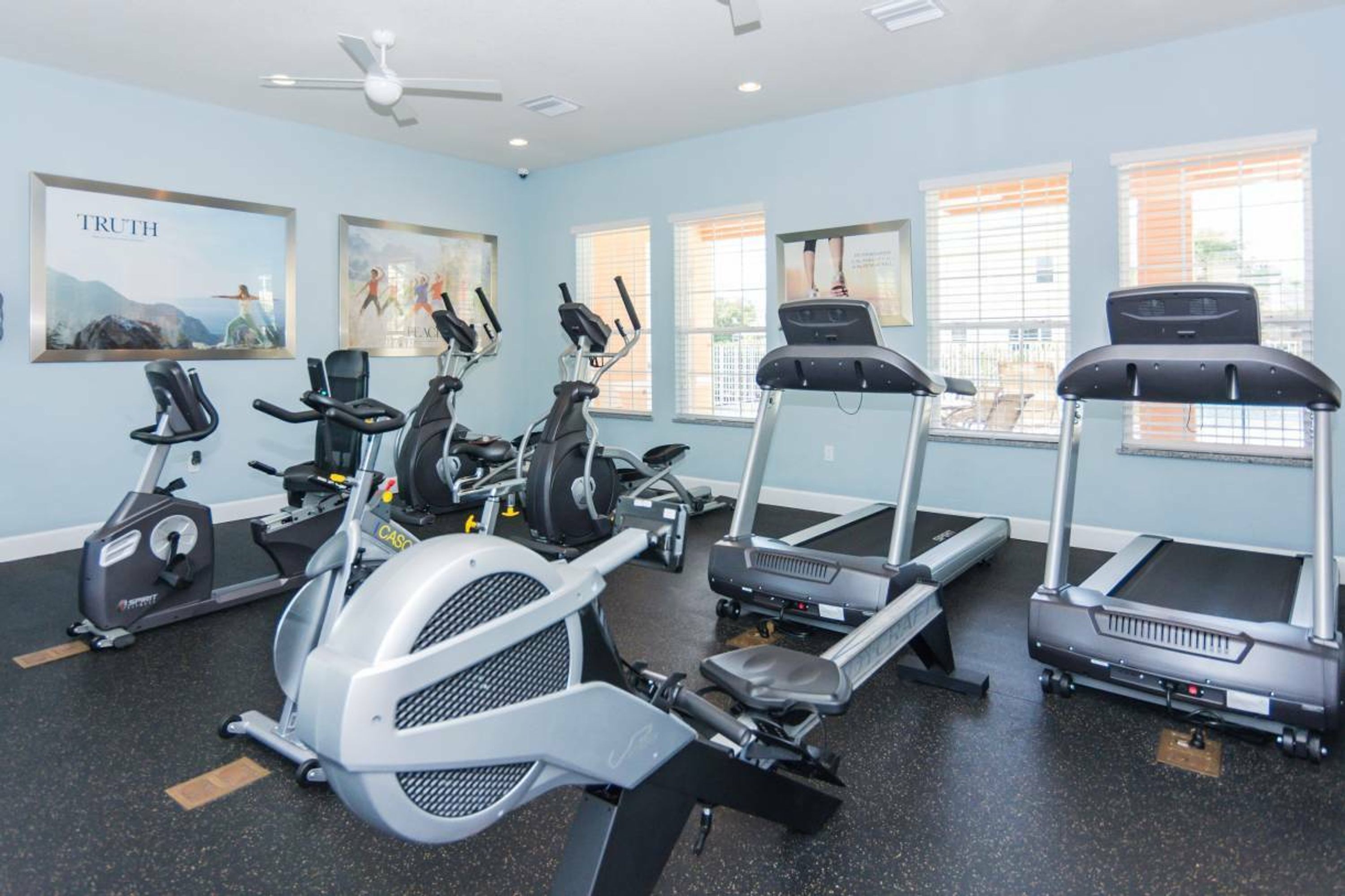 Un gimnasio con bicicletas estáticas, cintas de correr y elípticas.