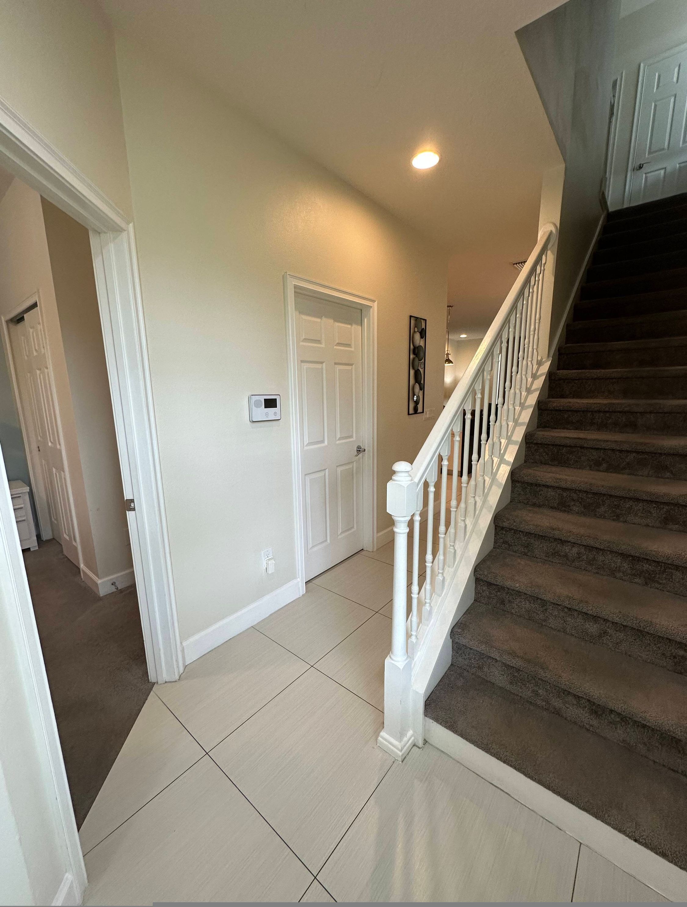 A staircase with a white railing leading to a landing.