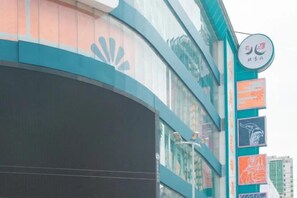 Un edificio con fachada curva, un logotipo destacado y varios banderines verticales.