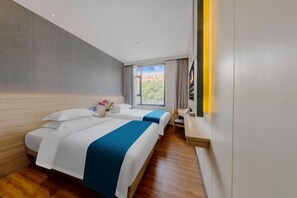 A hotel room with two beds, a wooden floor, a large window, and a flat-screen TV. - ZhuXing Hotel (Guangzhou)