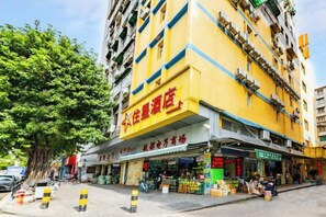 A multi-story building with a yellow facade and a storefront on the ground level. - ZhuXing Hotel (Guangzhou)