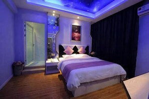 Quarto com cama, mesas de cabeceira, luminária no teto, janela e porta.