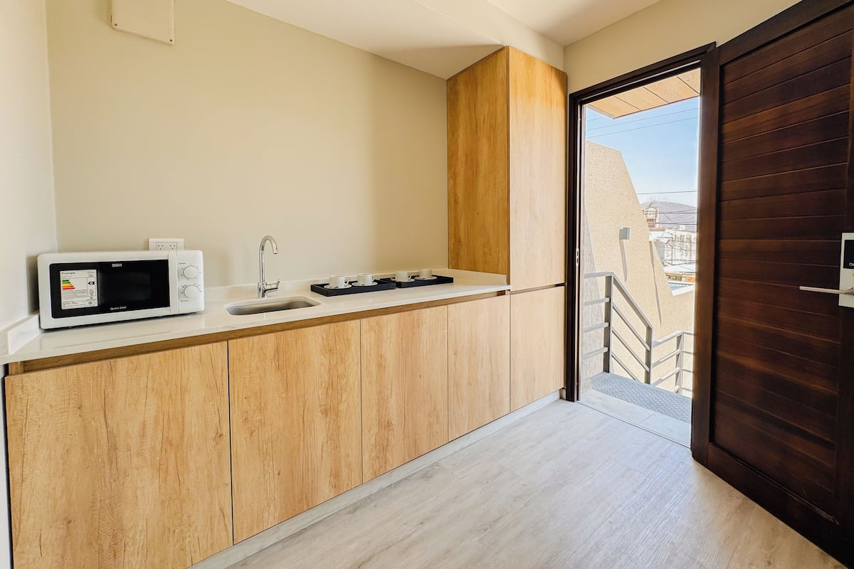 A modern kitchen with a microwave, sink, and wooden cabinets.