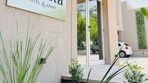 A sign for "Casa Foresta Hotel & Apartment" with a modern design, a wooden ceiling, and a car parked outside. - Casa Foresta (Salta)