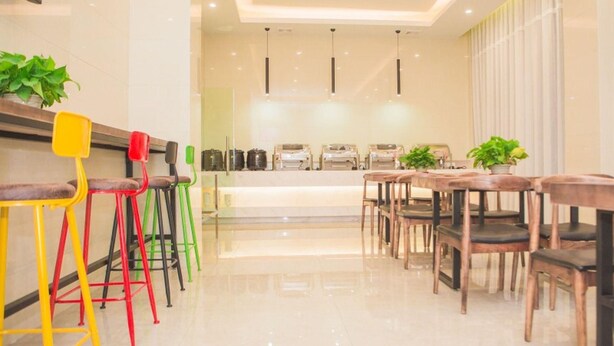 A modern dining area with a long counter and multiple chairs, including colorful stools.
