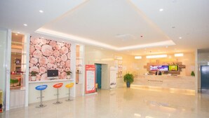 A spacious lobby with a reception desk, colorful bar stools, a large wall mural, and a television screen. - Greentree Inn Yangzhou Jiangdu Xiaoji Town South Zhongxing Road Express Hotel (Yangzhou)