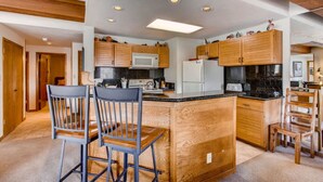 Une cuisine moderne avec des meubles en bois, un îlot central et des appareils électroménagers intégrés.