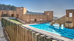 A modern building with a pool, wooden exterior, and a clear sky. -  NEW 3BR/3Bath Ocean Views 2-min walk to Bluff Trail Close to Town (Sea Ranch)