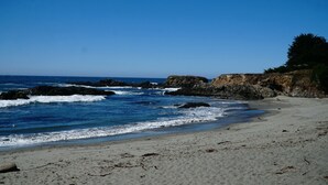 A beach with rocky outcrops and waves crashing onto the shore. -  NEW 3BR/3Bath Ocean Views 2-min walk to Bluff Trail Close to Town (Sea Ranch)