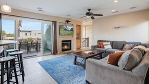A spacious living area with a fireplace, a sofa, and a coffee table. - Beach Dream - Steps to the boardwalk & beach with AC, WiFi, deck, prime location! (San Diego)