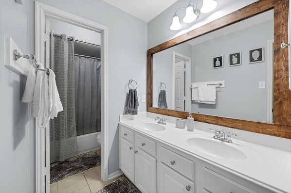 A bathroom with a large mirror, two sinks, and a shower. - Luxury Dream Home with Pool and Surround Sound System. Close to Splash pad, etc. (Spring)