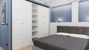 A bedroom with a bed, a wardrobe, and a mirror. - [Center - Metro] Stylish and Modern Two-room apartment (Turin)