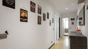 A hallway with posters on the walls, a light switch, and a door at the end. - GuestHost - Nice apartment of 68 square meters, ideal for 5 people, located on the second floor of a building with a lift (5/6 steps to access it). Located in a central position and a 7-minute walk from La Spezia Centrale train station.The apartment is i (La Spezia)