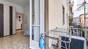 A balcony with a drying rack, a window with curtains, and a view of neighboring buildings. - GuestHost - Nice apartment of 68 square meters, ideal for 5 people, located on the second floor of a building with a lift (5/6 steps to access it). Located in a central position and a 7-minute walk from La Spezia Centrale train station.The apartment is i (La Spezia)