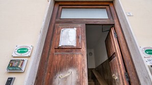 A wooden door with a handle, a sign on the wall, and a staircase leading inside. - GuestHost - Nice apartment of 68 square meters, ideal for 5 people, located on the second floor of a building with a lift (5/6 steps to access it). Located in a central position and a 7-minute walk from La Spezia Centrale train station.The apartment is i (La Spezia)