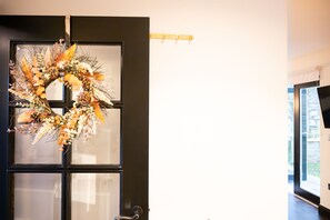 A door with a wreath, a black door frame, and a window with blinds. - Northern Hideaways, Apple Store, Ellingham (Chathill)