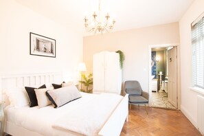 A bedroom with a large bed, a chair, a wardrobe, and a chandelier. - Northern Hideaways, Otterburn (Otterburn)