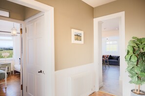 A hallway with a white door, a radiator, and a framed picture on the wall. - Northern Hideaways, Otterburn (Otterburn)