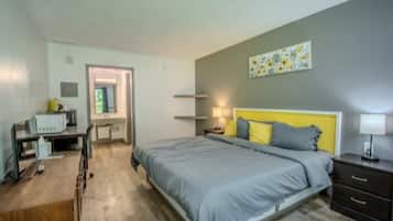 Une chambre à coucher avec un lit, des tables de chevet, un bureau et une chaise.