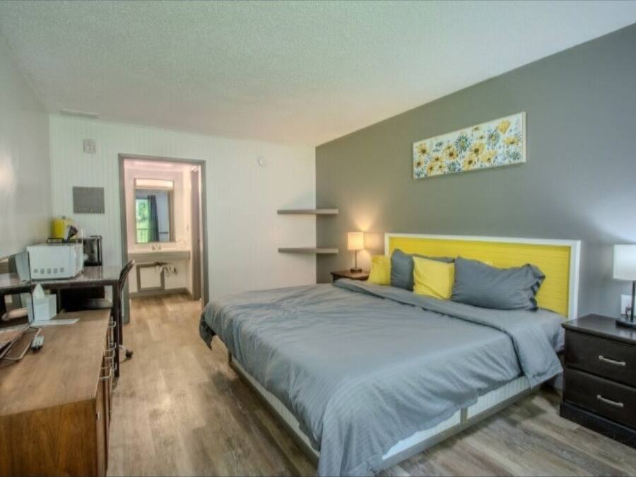 Une chambre à coucher avec un lit, des tables de chevet, un bureau et une chaise.