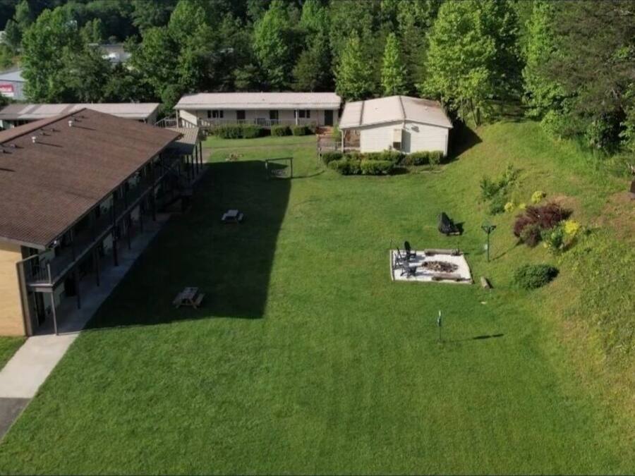 A building with a flat roof and a large open area with a fire pit.