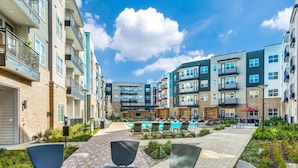 A courtyard with a fire pit, outdoor seating, and a swimming pool surrounded by multi-story buildings. - Best stay in Austin (Austin)