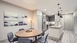 A modern kitchen with a central island, grey chairs, and a dining table. - Best stay in Austin (Austin)