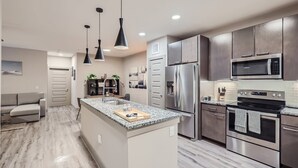 A modern kitchen with a central island, stainless steel appliances, and pendant lighting. - Best stay in Austin (Austin)