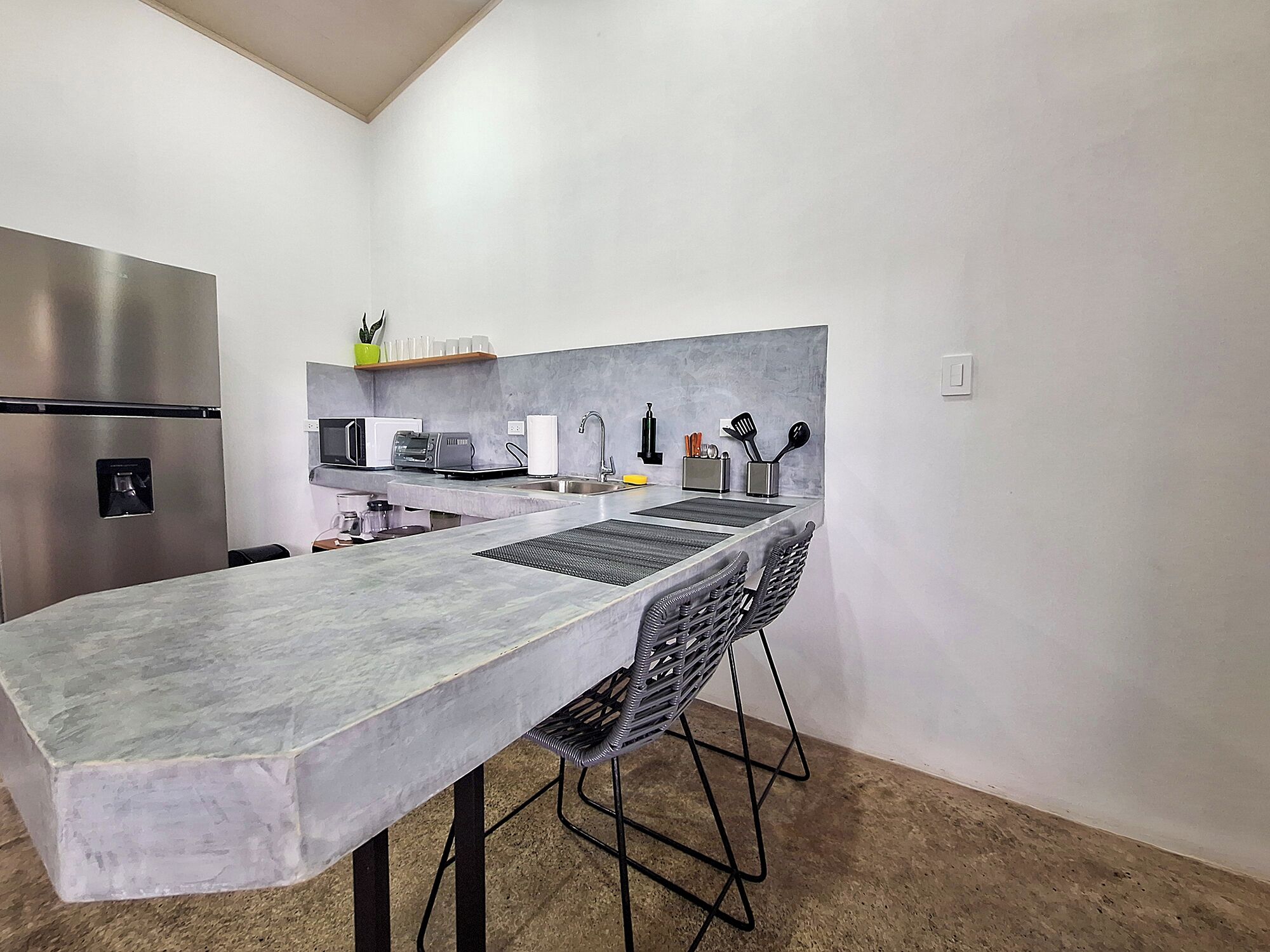 Uma cozinha moderna com uma ilha grande, eletrodomésticos de aço inoxidável e design minimalista.