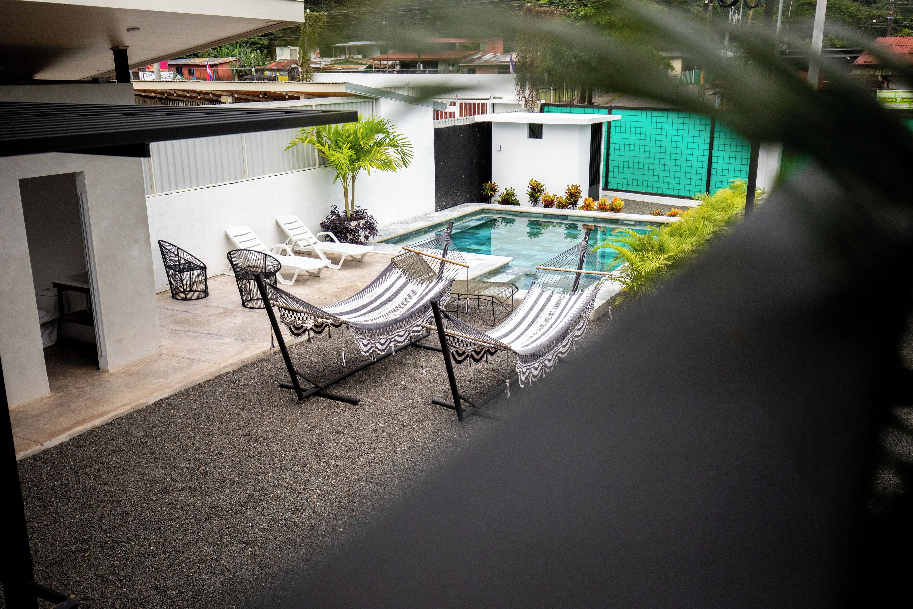 A modern outdoor pool area with lounge chairs and a small table.