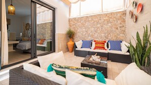 A modern living area with a sofa set, a coffee table, and a large window. - Casa Flor del Rocío – Seville – 4 Bedrooms for 8 – AC Throughout – Terrace & Parking (La Rinconada)