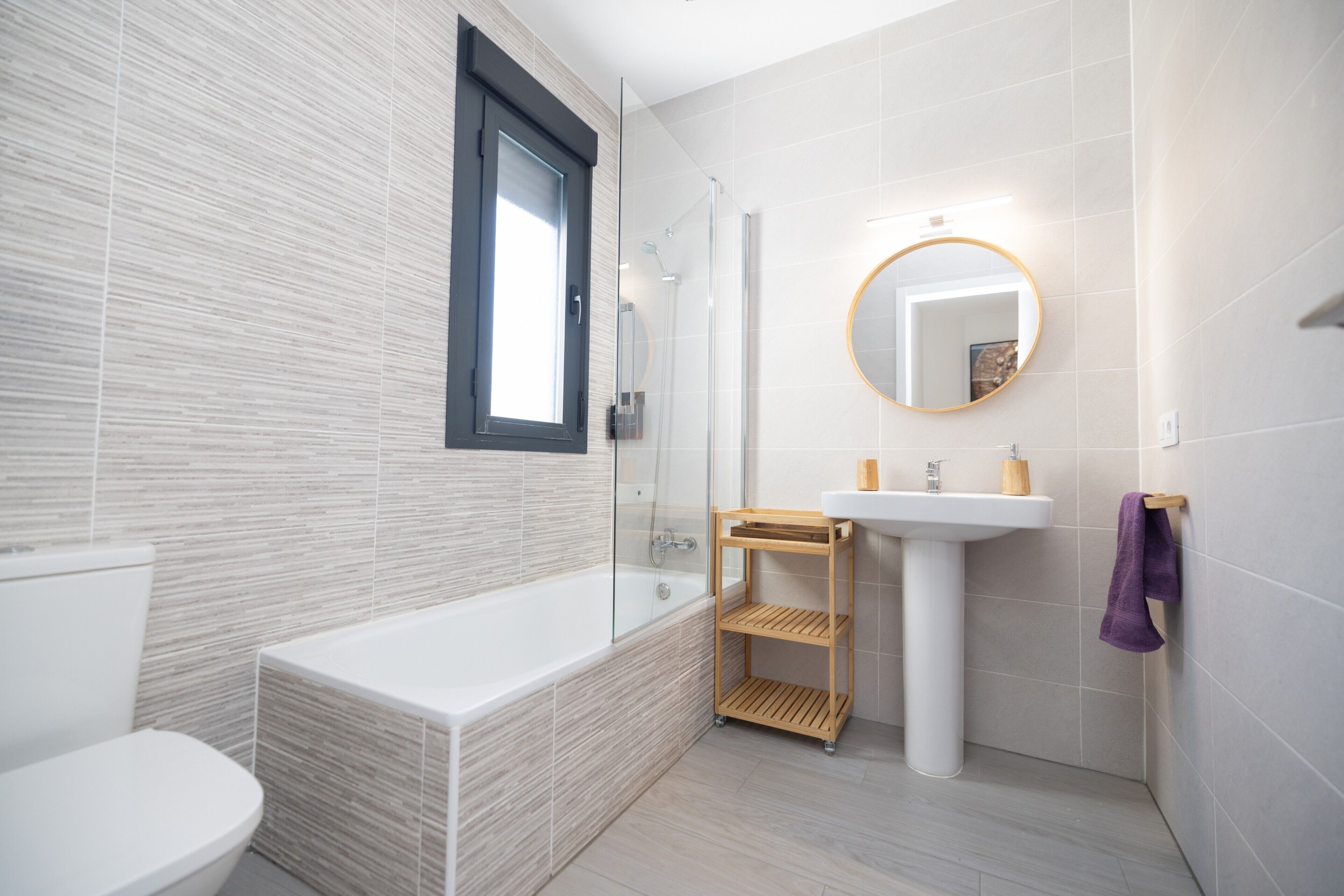 A modern bathroom with a bathtub, toilet, and sink.