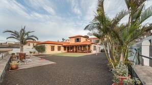 A house with a patio, outdoor furniture, and potted plants. - Vacation Home 'Casa Tagoro, Facing The Ocean' with Sea View, Private Terrace and Wi-Fi (Tacoronte)