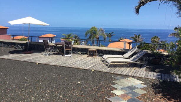 A wooden deck with lounge chairs and a table, overlooking the ocean. - Vacation Home 'Casa Tagoro, Facing The Ocean' with Sea View, Private Terrace and Wi-Fi (Tacoronte)