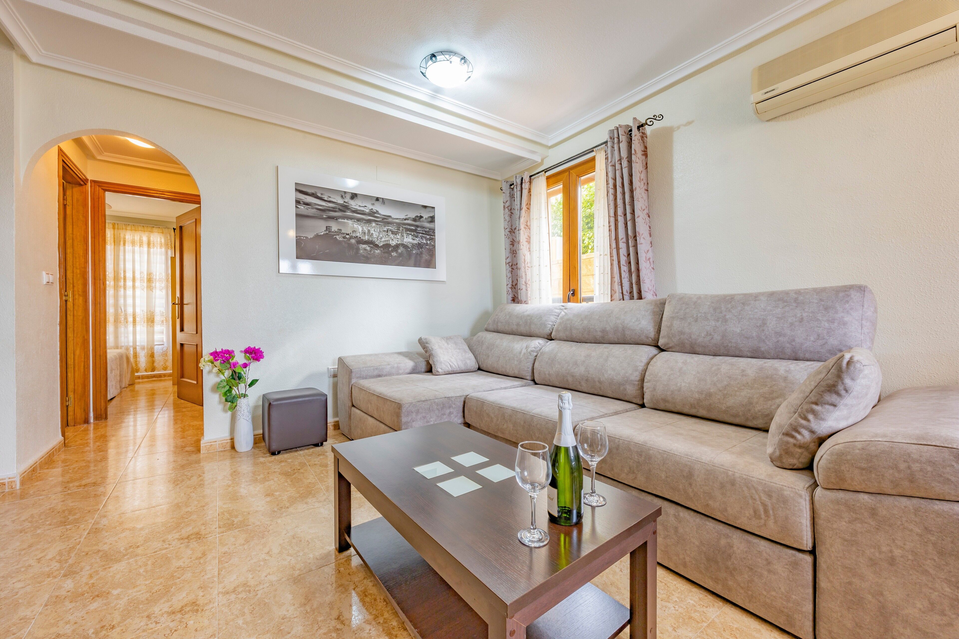 Uma sala de estar com sofá, mesa de centro e um quadro na parede.