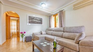 A living room with a sofa, a coffee table, and a framed picture on the wall. - Holiday Home 'Adosado En Finestrat' with Mountain View, Wi-Fi and Air Conditioning (Finestrat)
