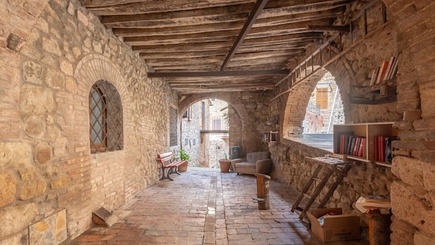 A stone-walled interior with a wooden ceiling, a bench, a sofa, and a bookshelf. - Apartment 'Sotto Gli Archi' with Mountain View (Civitella Paganico)