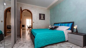Un dormitorio con cama, mesita de noche y espejo.