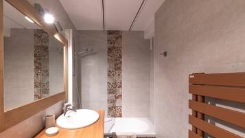 Une salle de bain moderne avec un meuble-lavabo en bois, un grand miroir, une douche et une baignoire.