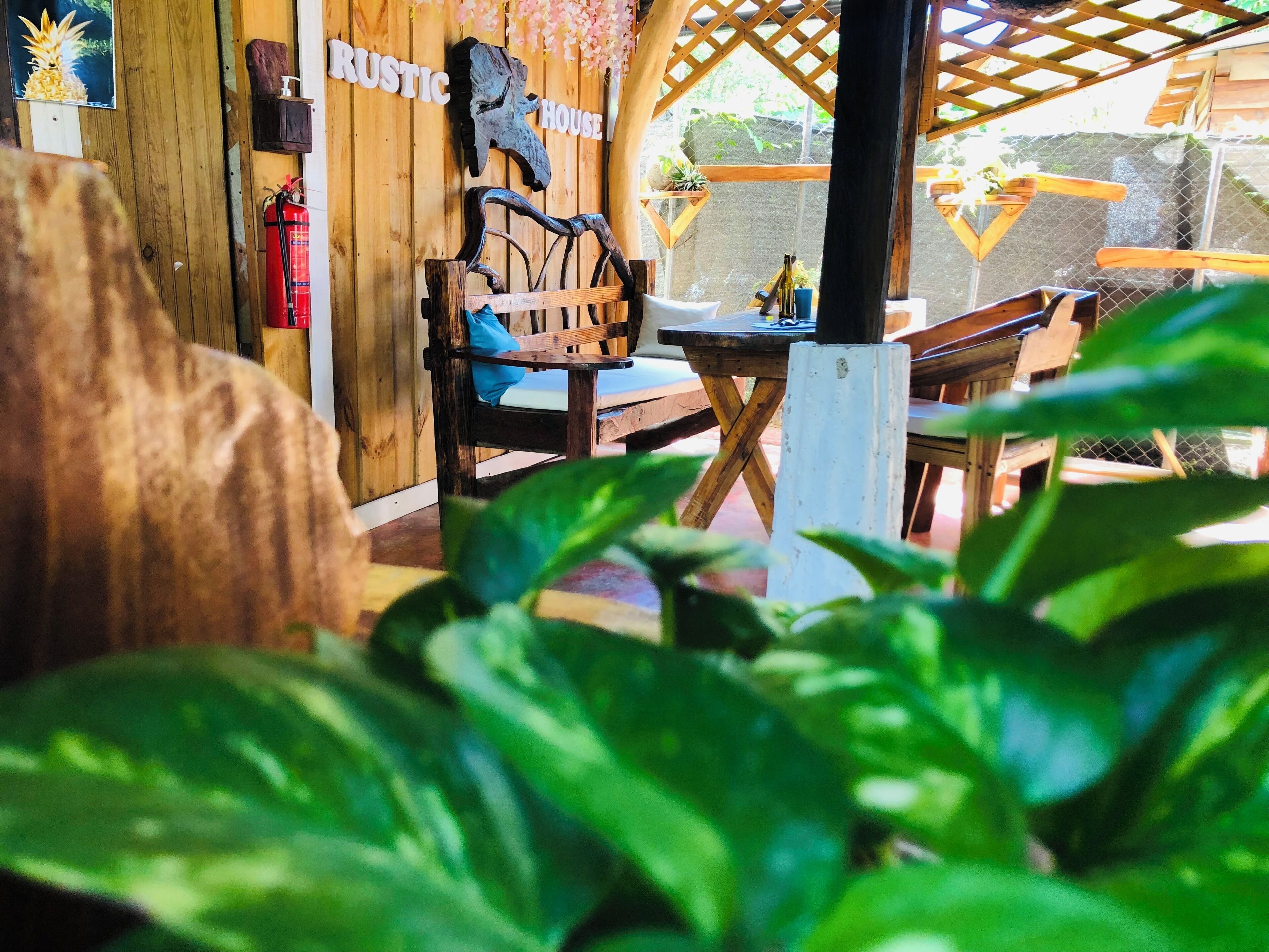 Un interior rústico de madera con un banco, una mesa y un letrero que dice 'RUSTIC HOUSE'.