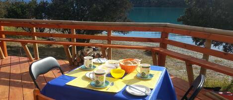 A table set outdoors with a view of a lake and mountains.