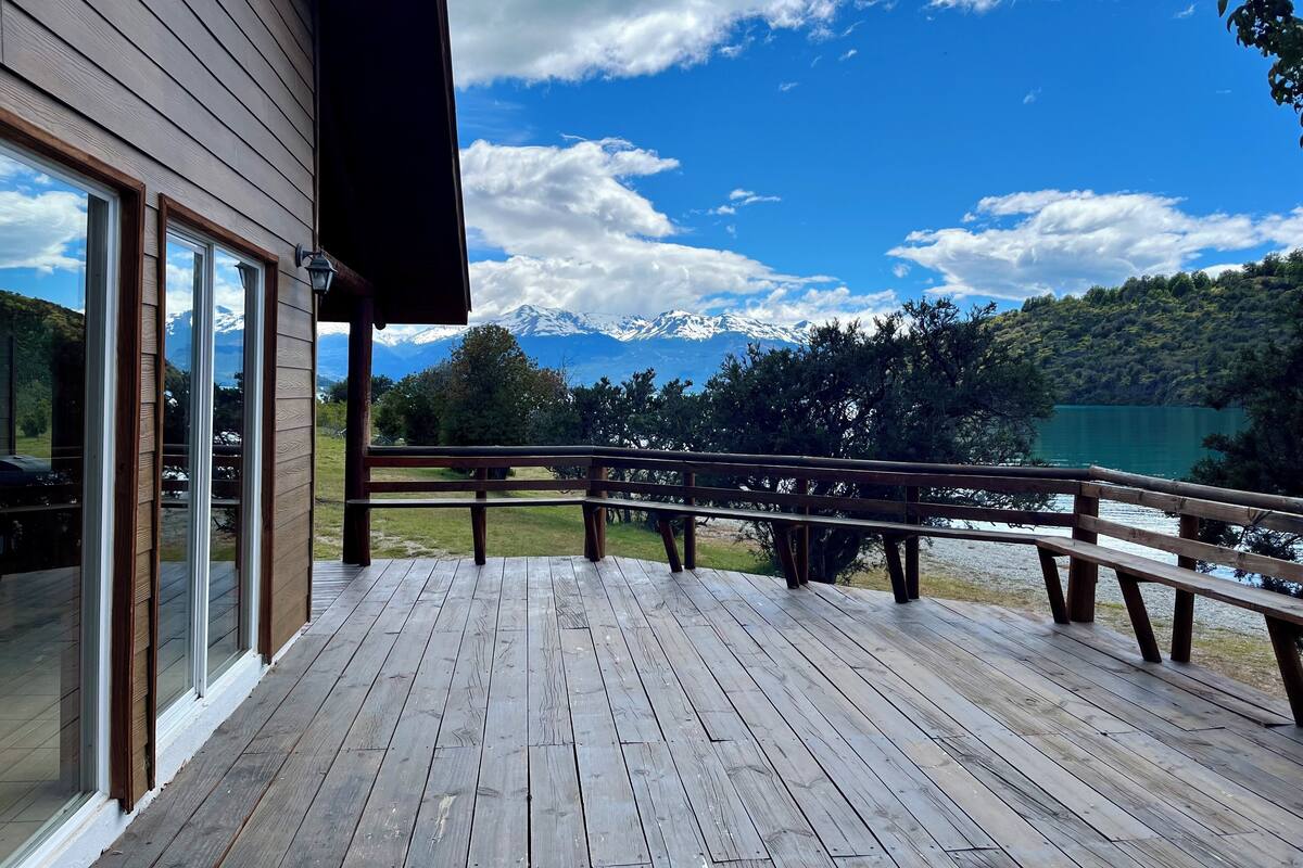 A wooden deck with a view of a lake and mountains.