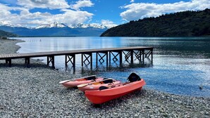 A calm lake with a wooden dock extending into the water, surrounded by a rocky shore. - Patagonia 47g (Chile Chico)