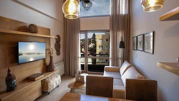 Departamento Deluxe, balcón, vista a la montaña | Área de sala de estar | Televisión de pantalla plana