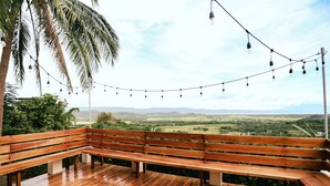 A wooden bench on a balcony with a view of a green landscape and mountains. - Shepherd's Ridge Mountain Resort (Mabitac)