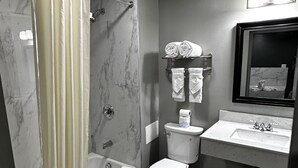 A bathroom with a shower, toilet, and sink.