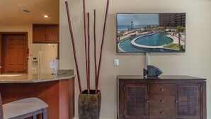 Vestíbulo de hotel con vista a la piscina, una recepción y una zona de bar.